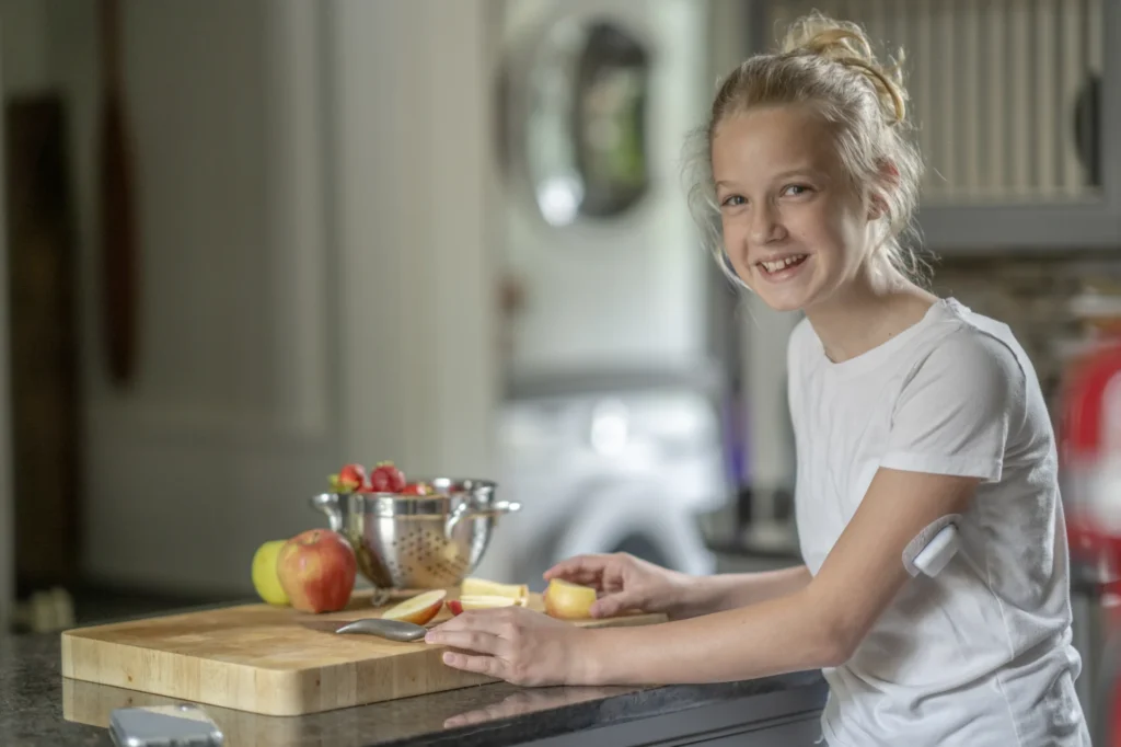 Girl living with Type 1 Diabetes and showing a diabetes management device on her arm